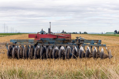 disc harrow operating in dusty and muddy agricultural soil conditions